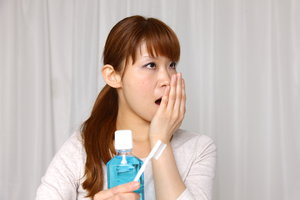 A girl tries to cure her halitosis with mouthwash and brushing